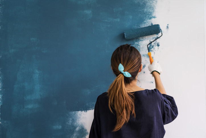 woman painting interior wall